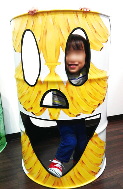 顔がくり抜かれたドラムカンに、バナナが描かれている