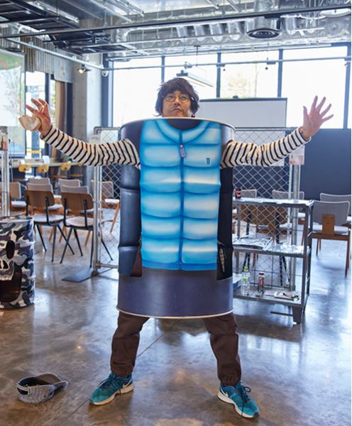 ダウンジャケットが描かれたドラム缶を着ている人