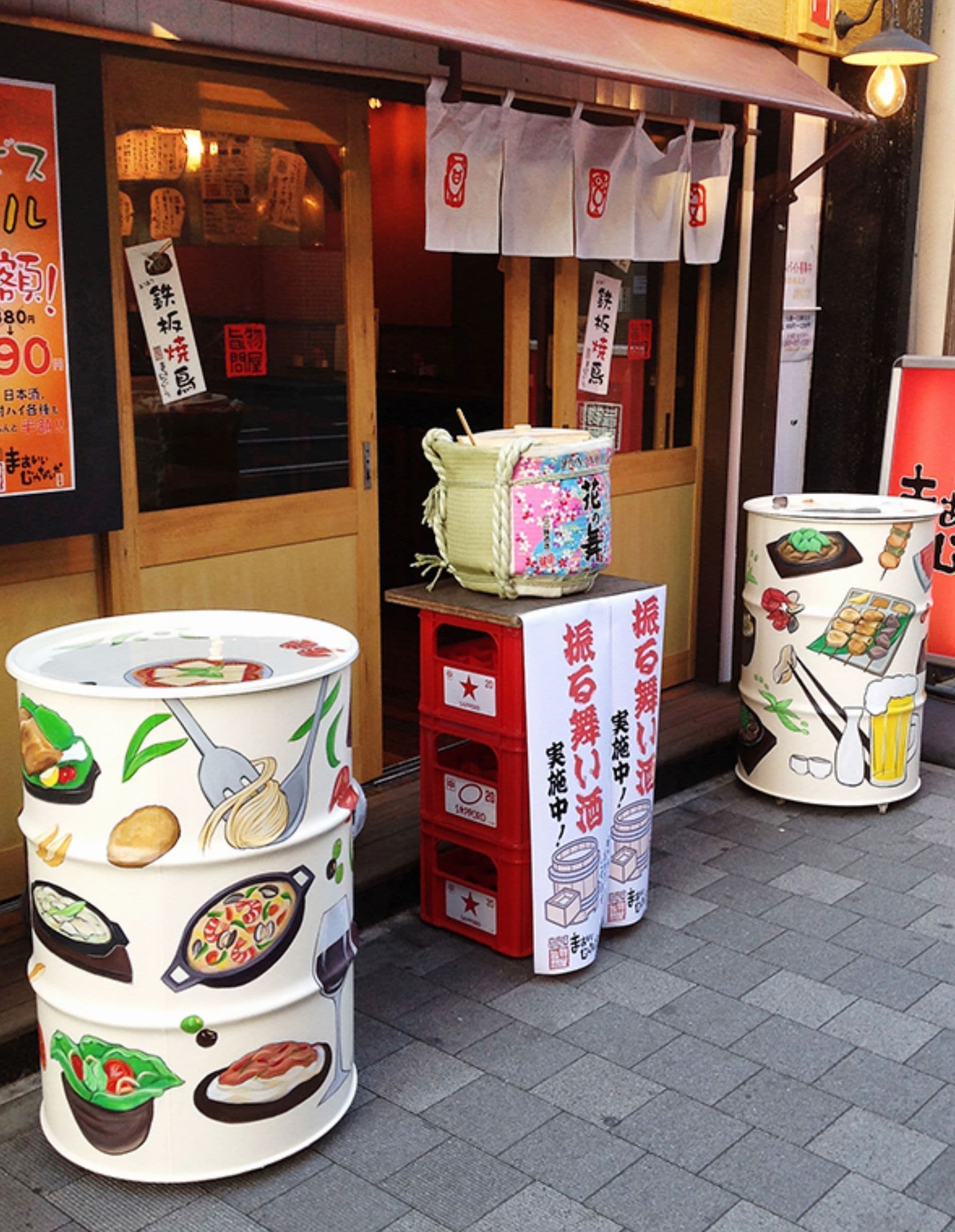 居酒屋の入口にメニューが描かれたドラムカン