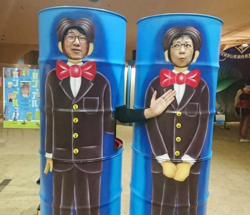 ドラムカンの顔ハメアート作品で漫才している